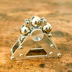 all silver fidget spinner made up of individual silver metal balls and a frame holing them together, and a silver metal stand to make it a desk spinner.