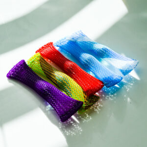 5 marble mesh fidgets side by side. The fidgets are over 2 blocks of light and 1 block of shadow. The mesh is shimmering in the light, and it's reflecting a shadow that has light holes in it.