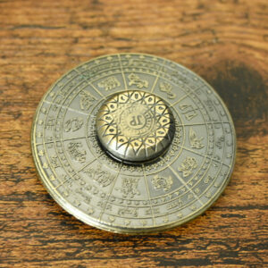 intricate horoscope calendar and symbols around the spinner and on a rustic wood table