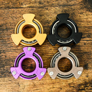 all 4 colors of metal fingertip fidget spinners on a wood table forming a square shape
