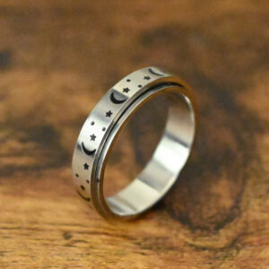 moon and star pattern engraved around a silver spinner ring