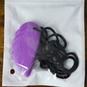 feather chew necklace inside the bag packaging on a wood table