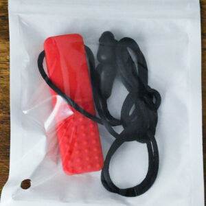 Red bar chew necklace inside the bag packaging
