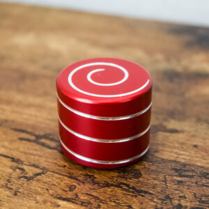 red desk spinner with a swirl on top and around the spinner to create a flowing effect